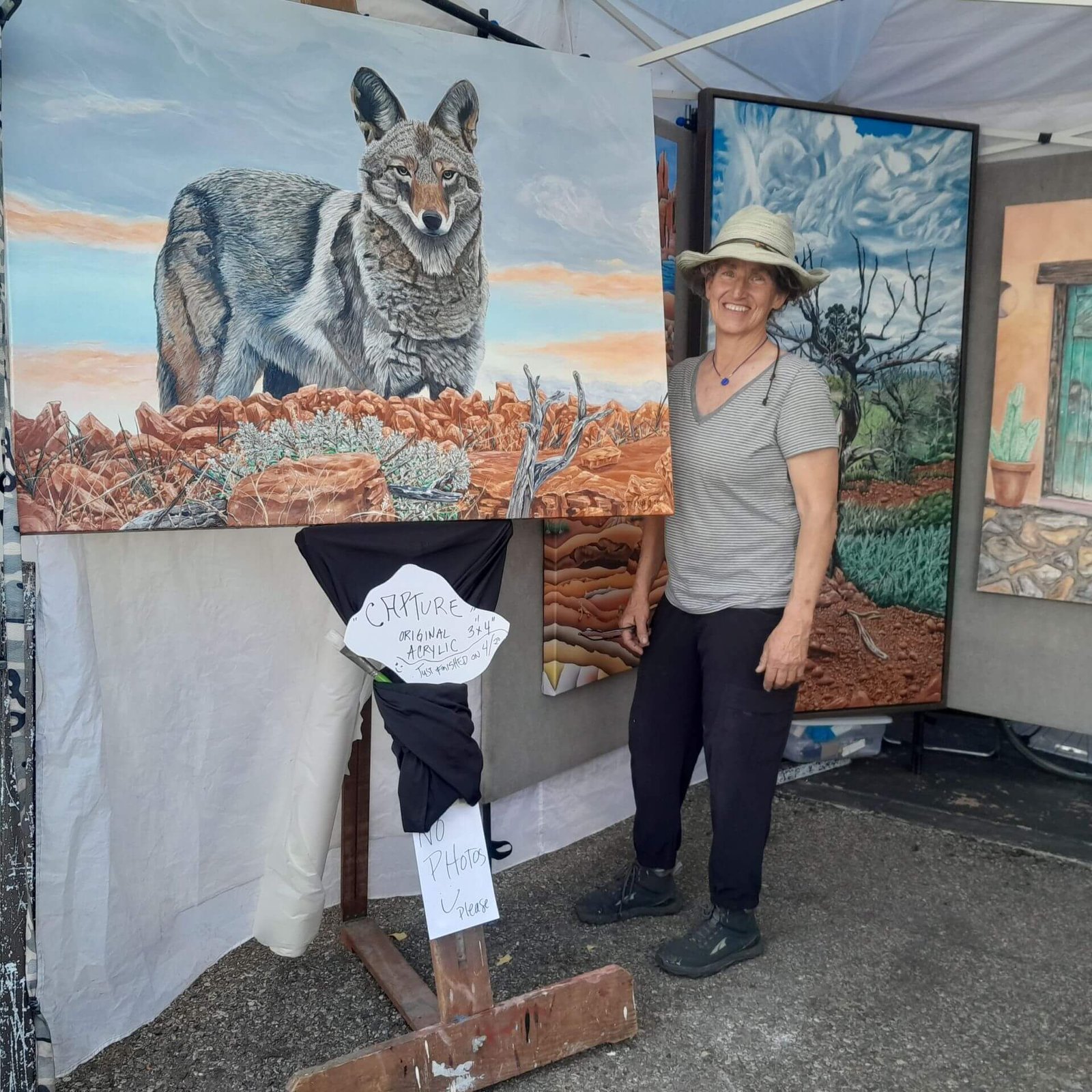 Me with my coyote painting at an outdoor art fair.