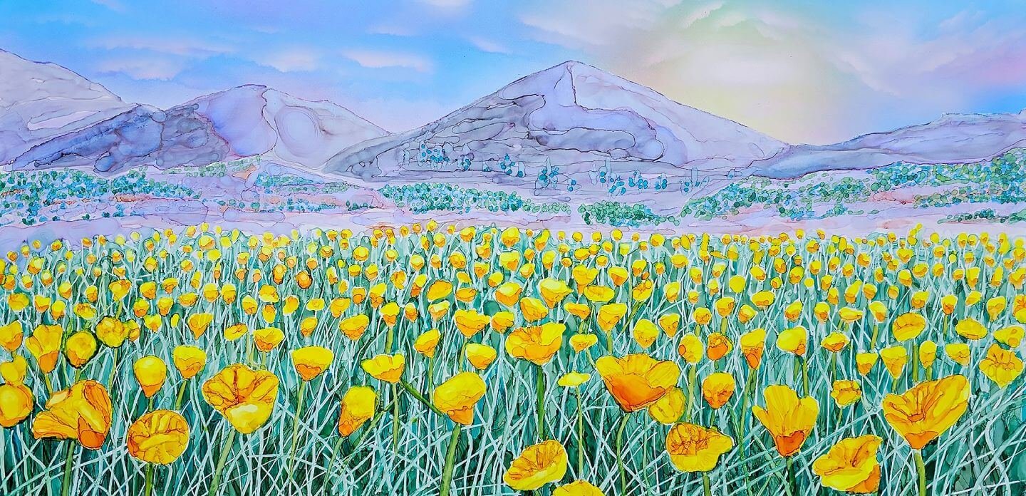 Wide field of yellow poppies with mountains in the background under a soft sky